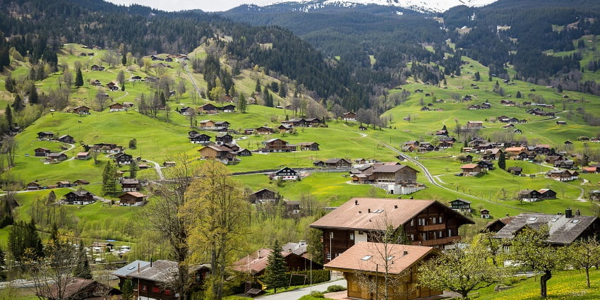 A captivating view of beautiful wooden houses on the lush green landscapes of Switzerland