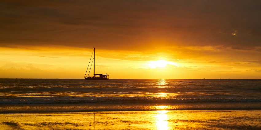A breathtaking silhouette of a sailboat during the sunset on a body of water for all.