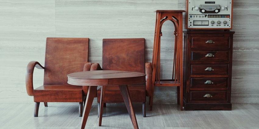 A scene with brown wooden chairs, a table, and a cabinet in warm light.