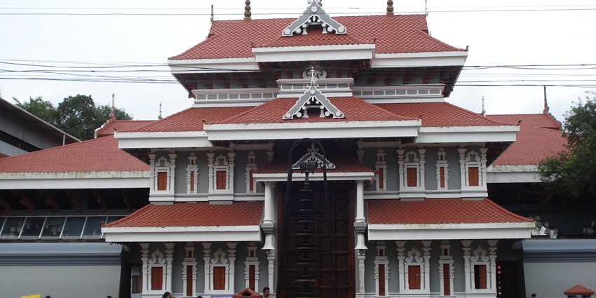 A frontal view of a temple in Kerala with a traditional architectural design and tall entry gate