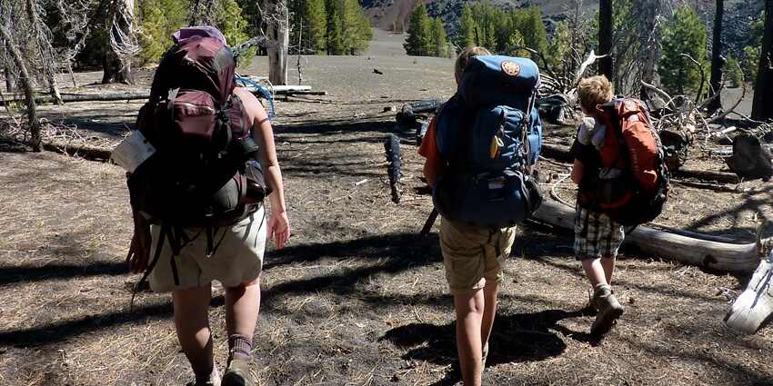 People backpacking for trekking in the hills on a beautiful day.
