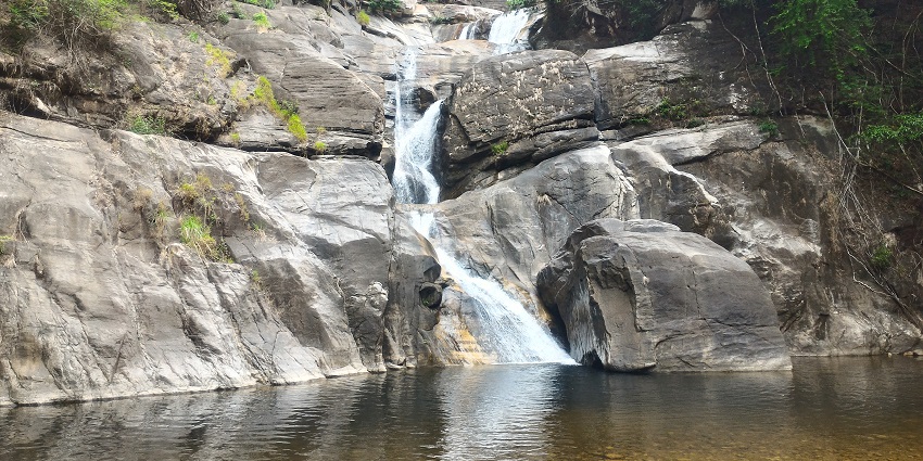 Trek in the dense green forests of Meenmutty Waterfalls, Wayanad, Kerala, India.