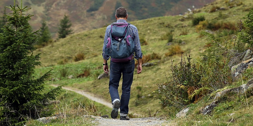 A hiker admiring the view of the surroundings of Vellappara Waterfalls in the forest