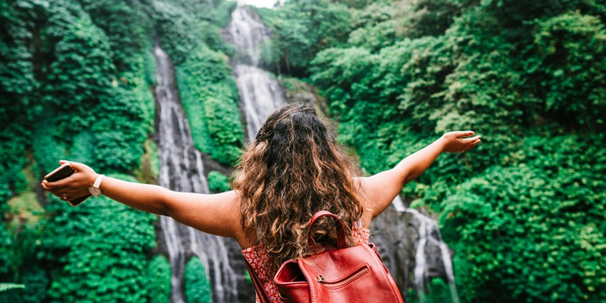 Female traveller admiring and trekking near amazing waterfall - Narangathode Waterfalls