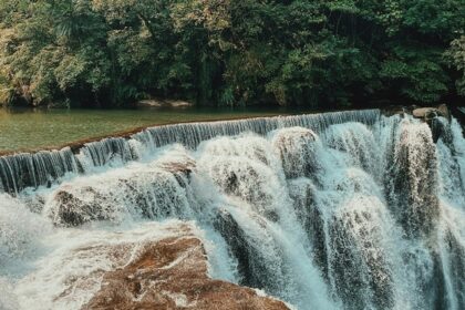 A mesmerising view of Trivandrum waterfalls flowing through rocks around lush greenery.