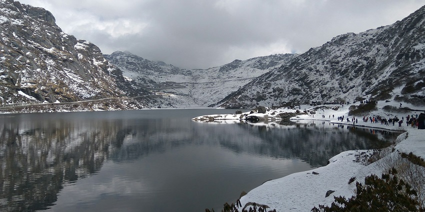 A view of the Tsomgo Lake in East Sikkim, a glacial lake surrounded by snowy mountains.