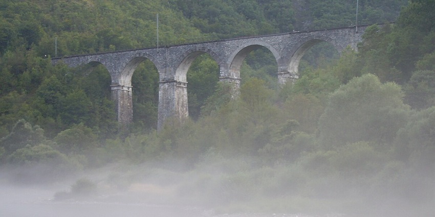 Railway bridge of Una standing amidst lush misty forests offering a enchanting view