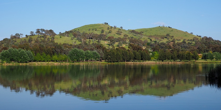 Witness the serene views at Urambi hills near calm Lake Tuggeranong in Kerala, India.