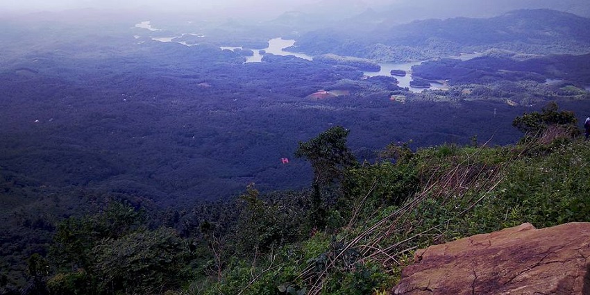 Misty morning at Vadakkemala Viewpoint near Vellappara Waterfalls with lush greenery.