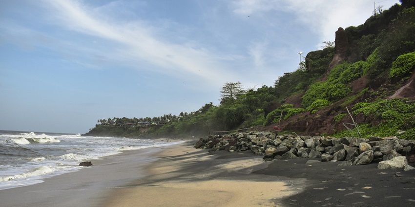 The rocky shoreline of the Varkala Beach in Kerala with the glistening tranquil waters