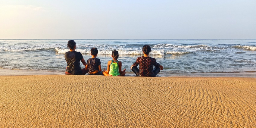 Kids sitting at the Varkala beach on of the best place for water sports in Varkala