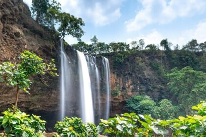 Breathtaking view of Vellappara Waterfalls in Kerala, cascading down lush green cliffs.