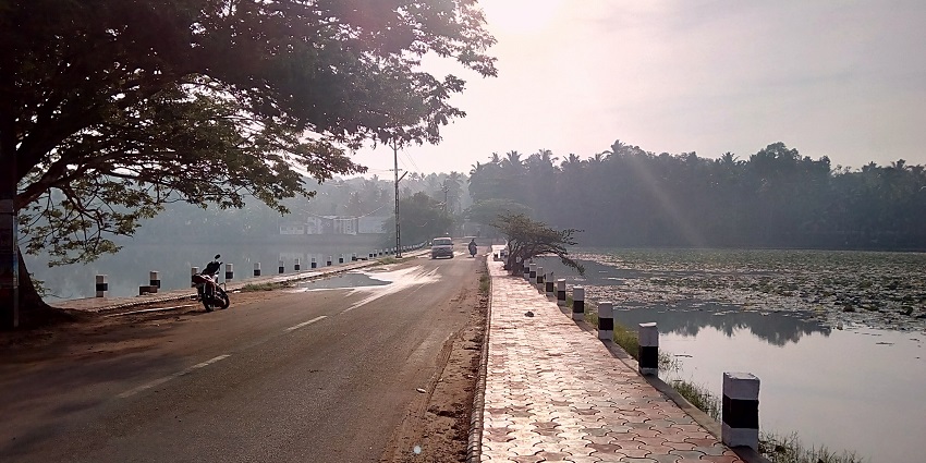 A straight road parallel to a lake