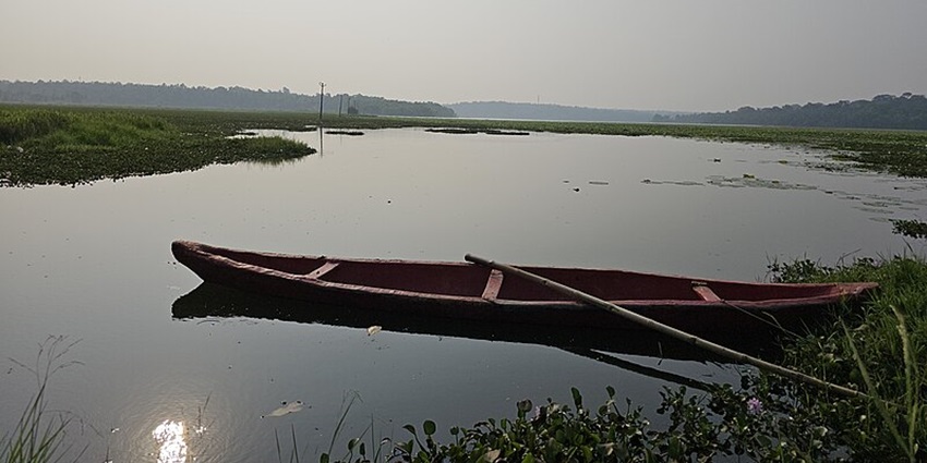 A boat sitting at the shore of Vellayani Lake