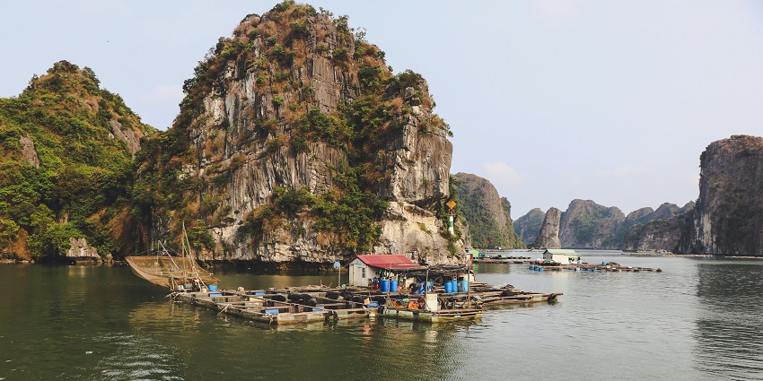 A wooden raft on a body of water in Quảng Ninh in Vietnam, a major tourist attraction