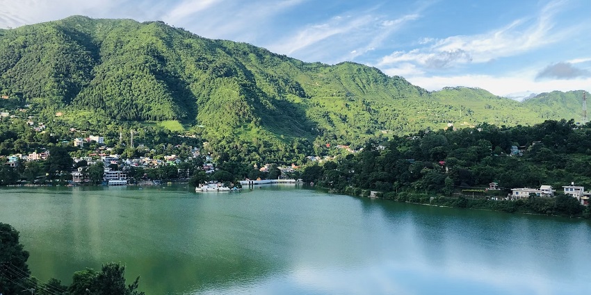 The view of Bhimtal Lake, Nainital, Uttarakhand is surrounded by the lush green hillside.