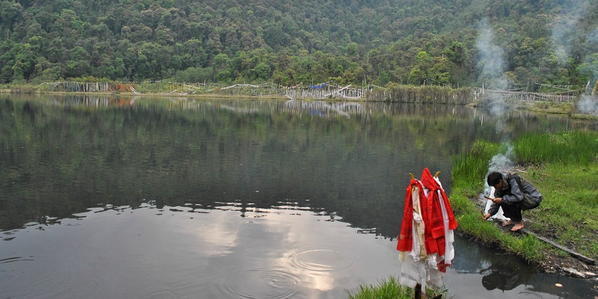 Lake surrounded by dense forest, known for its serene waters and spiritual significance.