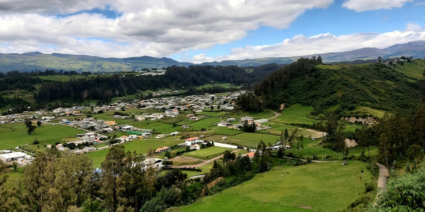 Picturesque view of a village surrounded by lush greenery and beautiful mountains.