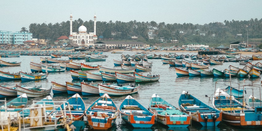A serene view of Vizhinjam Port, in Kovalam, Kerala decked with colourful boats.