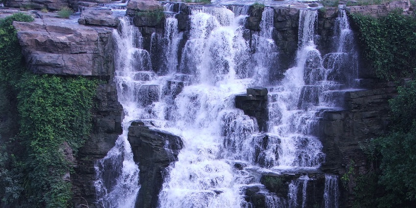 Witness the harmonious echoes of the water descending down the rocks of Keezharkuthu Falls