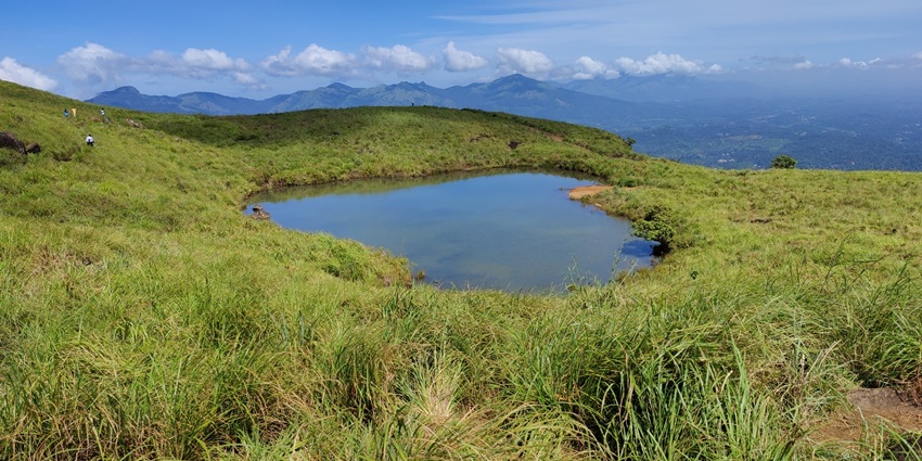 A mesmerising view of the heart-shaped lake on Chembra Peak in Wayanad, surrounded by greenery