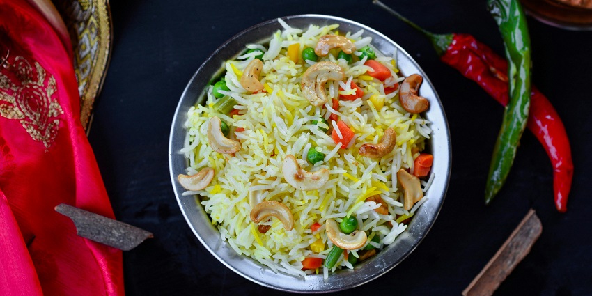 A tempting view of a plate served with vegetable Biryani and garnished with fried cashews.