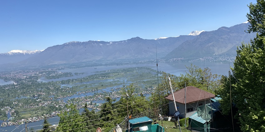 Awestruck view of the mountains and greenery from the top at the distance in the sunny sky