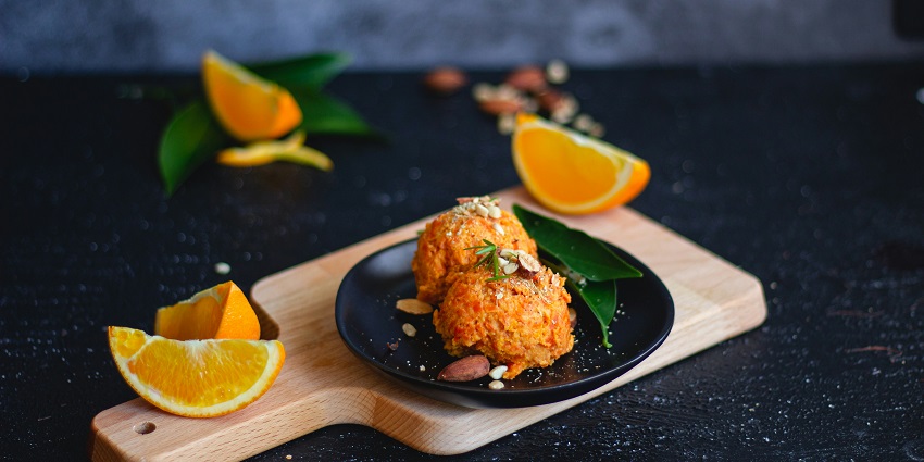 A tempting view of a plate served with cooked rice with sliced oranges on the side.