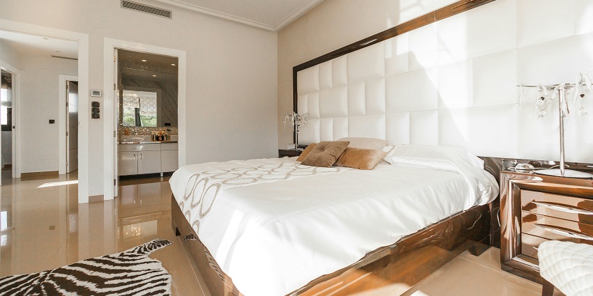 A breathtaking view of a bedroom with a bed lined with white sheets and pillows.
