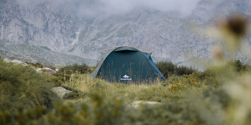 A view of a grey tent on green grass, which can be used to stay while Amarnath Trekking.
