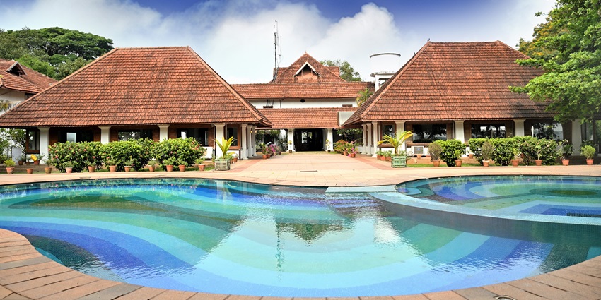 A picture of a resort in Kerala with a swimming pool on the front side