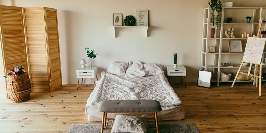 A stunning view of a beautiful room with a bed, shelves and plants with no people inside.