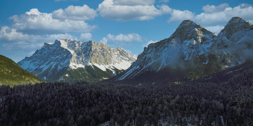 A view of a scenic valley in Kashmir that is enveloped by lush green forests and mountains