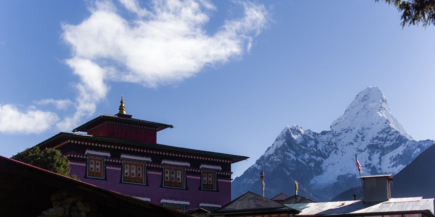 A monastery with a snow-capped mountain in the background