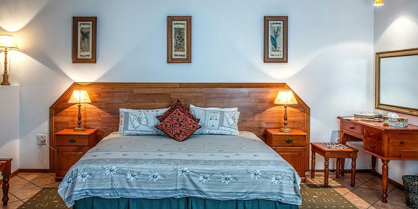 A cosy white bed cover drapes elegantly over a bed, set against a soft wall backdrop.