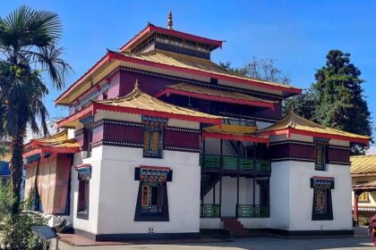 A breathtaking view of a monastery in Sikkim with red and yellow walls during the day.