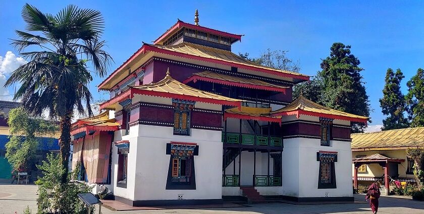 A breathtaking view of a monastery in Sikkim with red and yellow walls during the day.