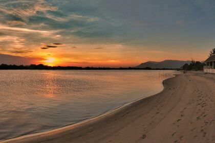 A breathtaking view of the sun settling down and the rays touching the azure waters.