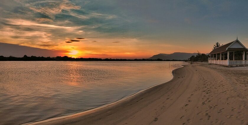 A breathtaking view of the sun settling down and the rays touching the azure waters.