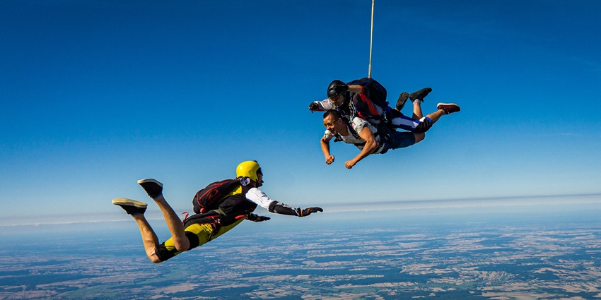 A few people skydiving together, enjoying the thrill of freefall with expansive aerial