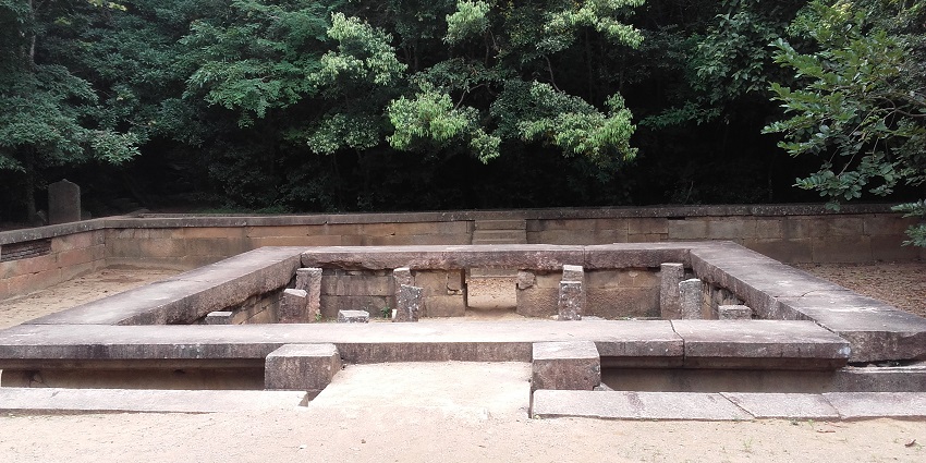 A serene resting spot in Ritigala, surrounded by lush greenery and ancient stone structures.