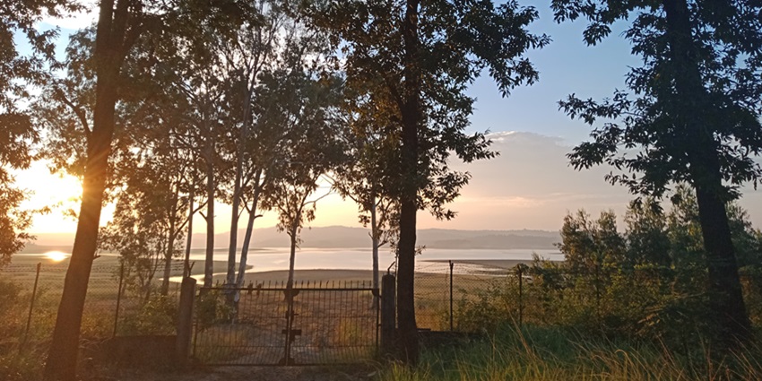 A scenic view from Umrangso, showcasing rolling hills, dense forests, and tranquil waters.