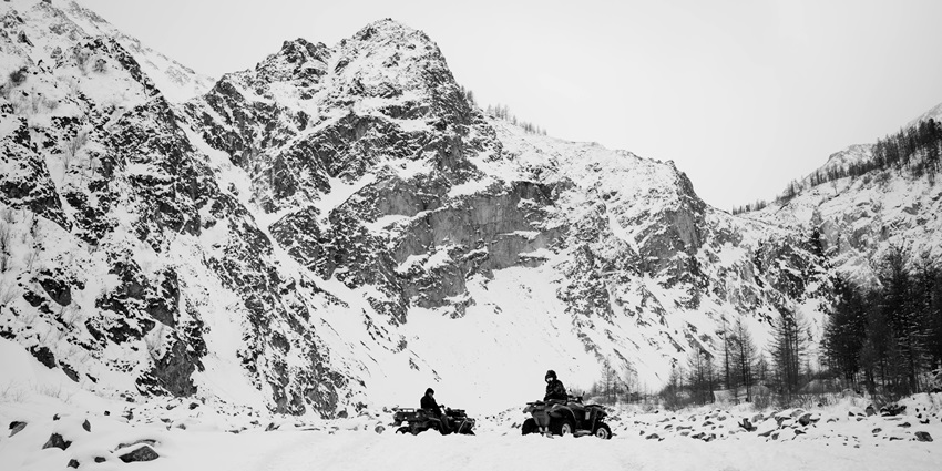 Image of ATV scooter riders around snow-capped mountains enjoying the chill winter and snow