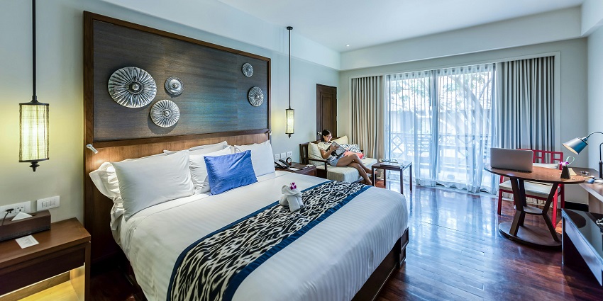 A person sitting in a beautifully designed bedroom with elegant furnishings and decor.