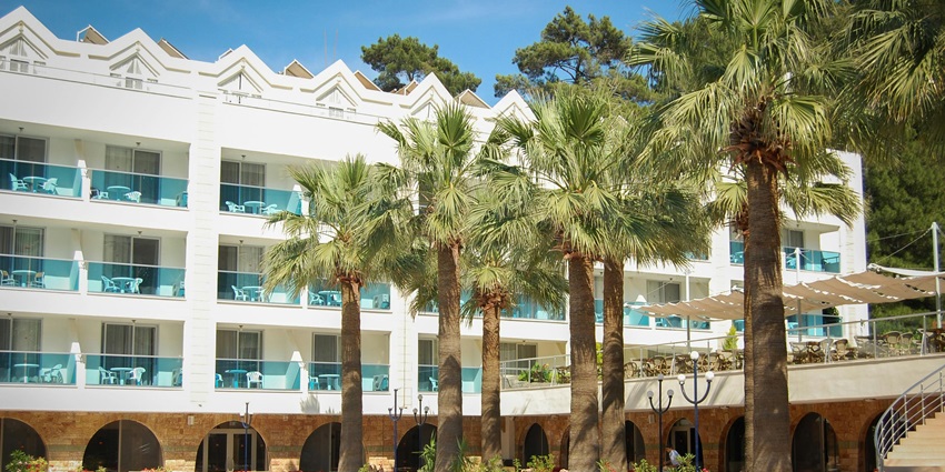 Snapshot of the white coloured hotel with beautiful pool and the plam trees near adventure park