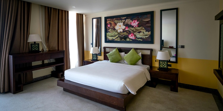 Cosy bed inside a hotel room, featuring crisp linens and a welcoming, comfortable setup.