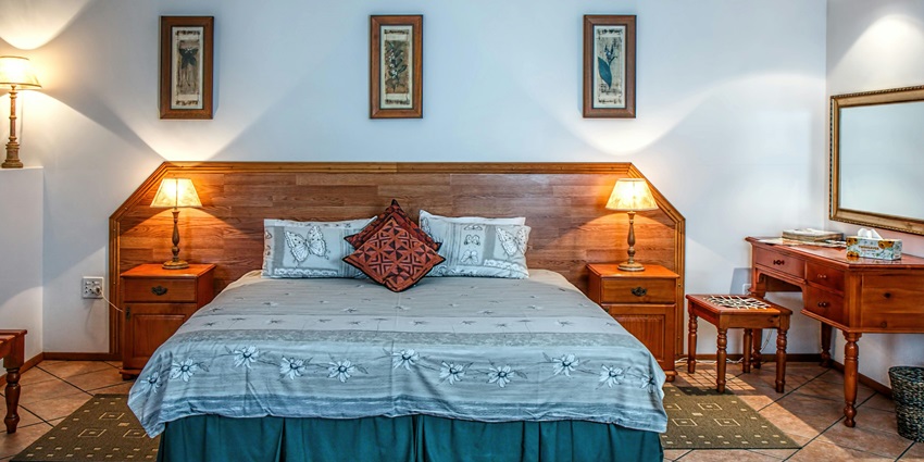 White bed cover neatly spread on a bed near a wall, creating a clean and fresh look.