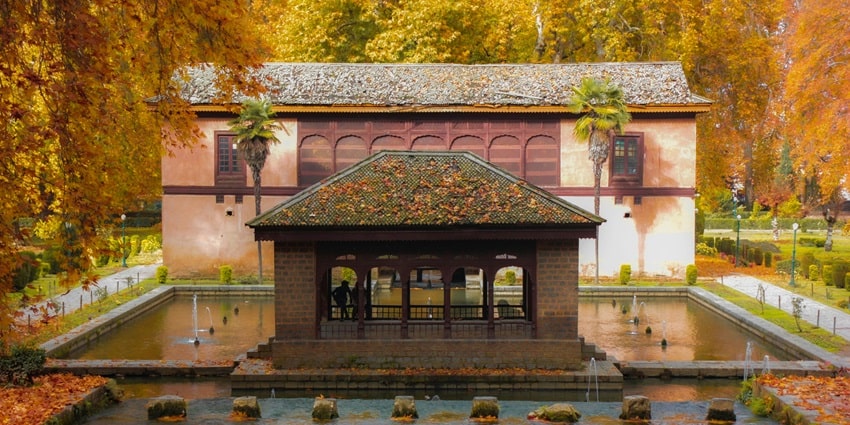 Enchanting view of a pavilion of the garden surrounded by crismon autumn leaves