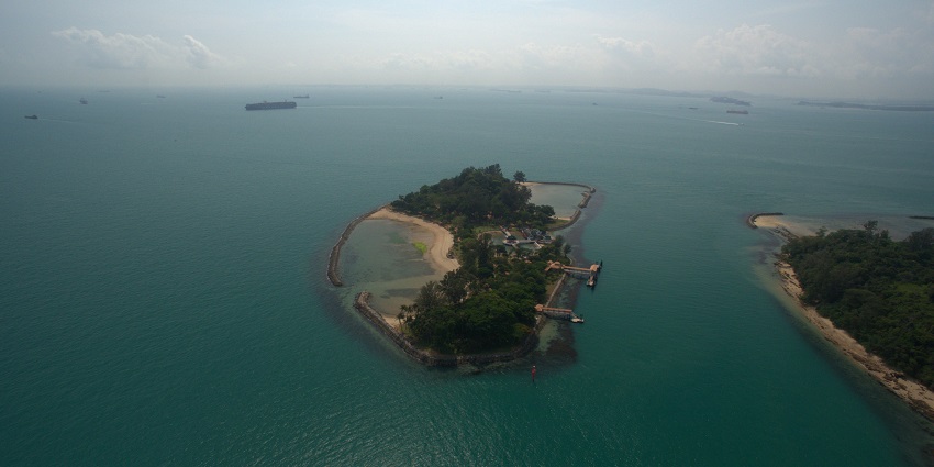Aerial view of an Island, showcasing pristine beaches, turquoise waters and greenery.