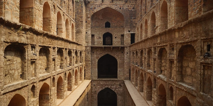 A picture of a historical monument in Delhi with intricate carvings on its walls